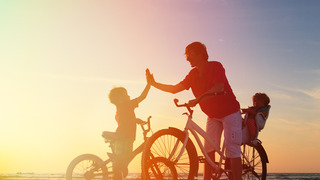 Biker family silhouette, father with two kids on bikes