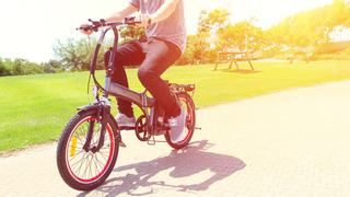 A man riding on electric bicycle in a park
