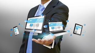 Businessman with computer phone and tablet in his hand
