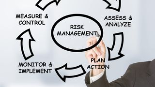 Businessman drawing risk management circle on transparent board